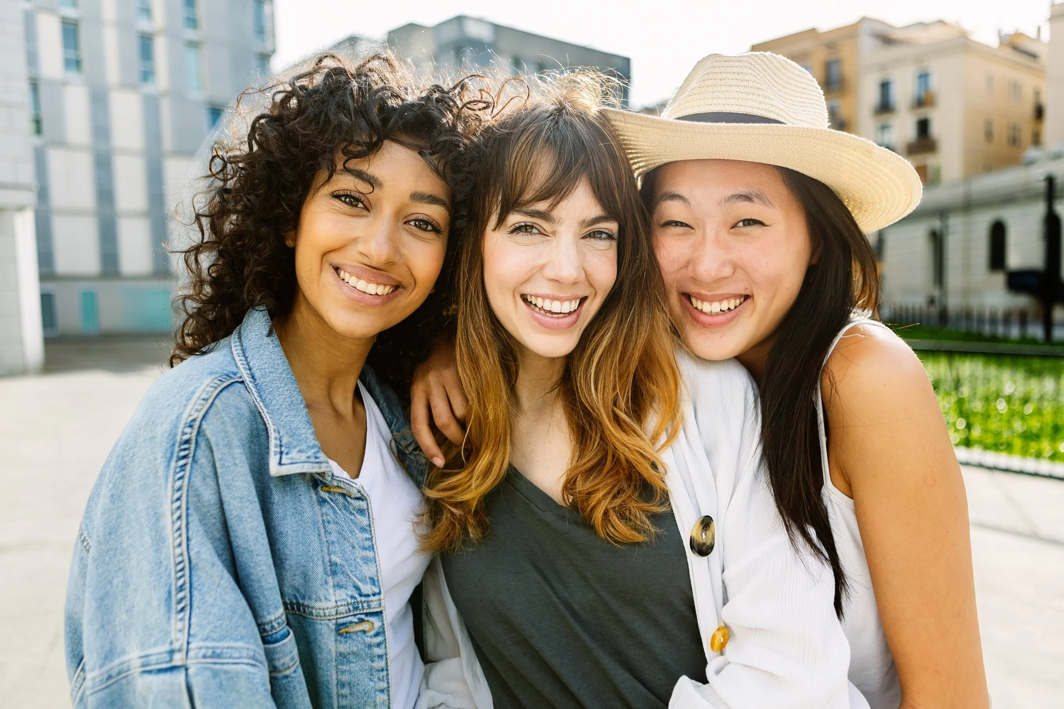 group of three diverse young women smiling
