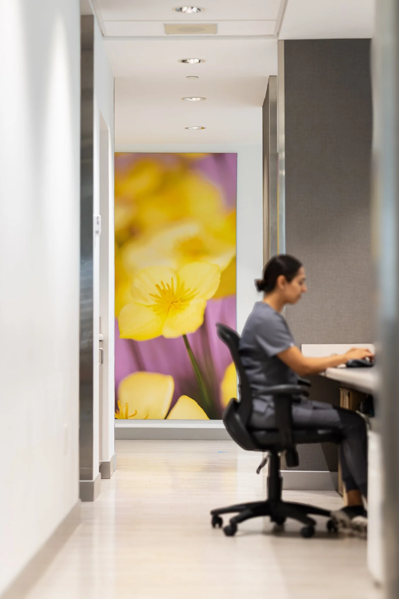 Nurse working on laptop with floral wall background