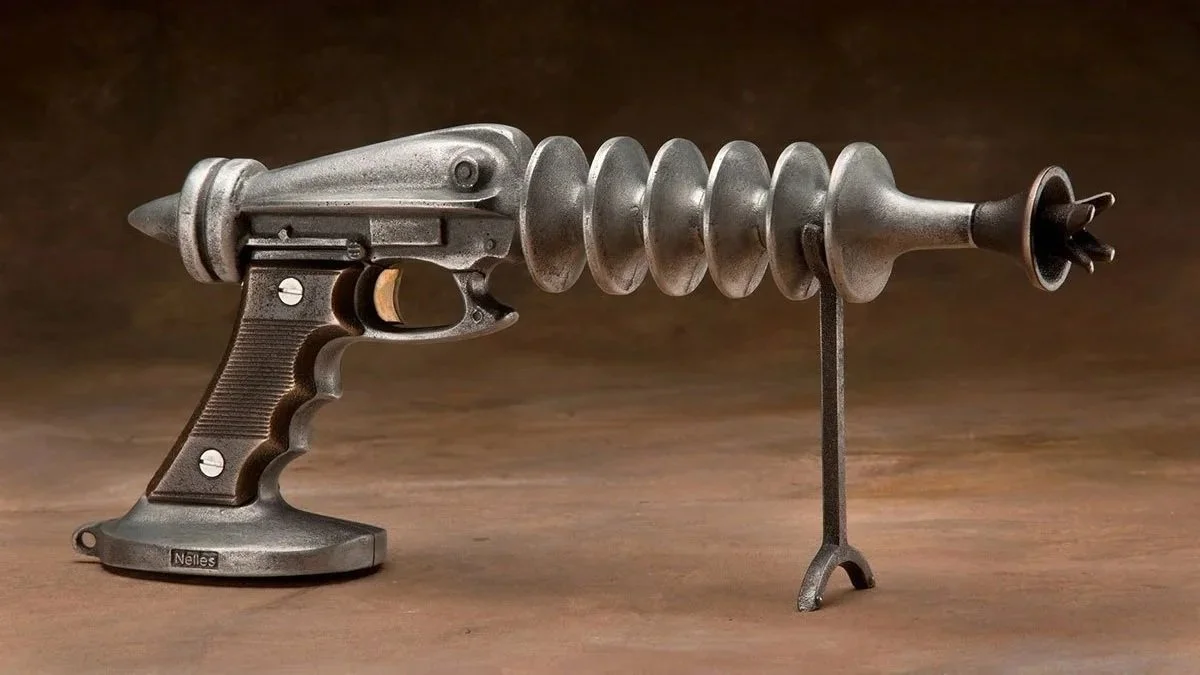 A steampunk-style gun with a handle and trigger, featuring metallic gears, spirals, and a tripod support.
