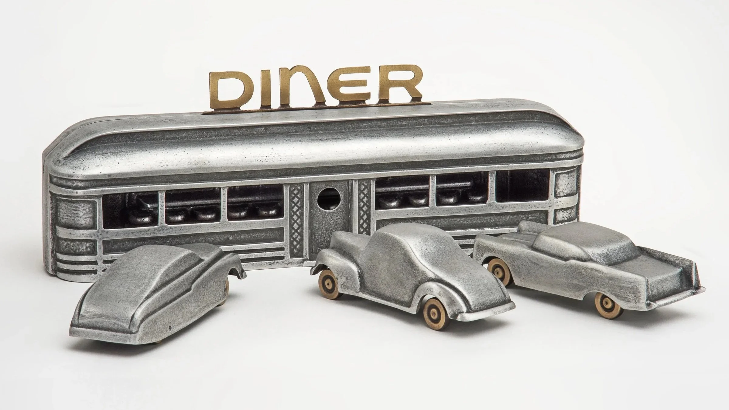 Vintage metal diner sign spelling out the word 'DINER' in uppercase letters