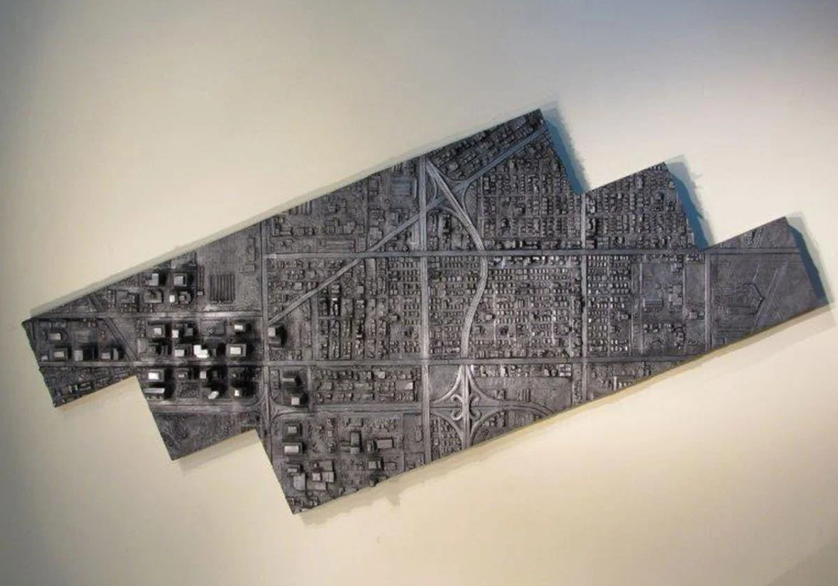 Wall art resembling a city map with roads and buildings in a modern design.