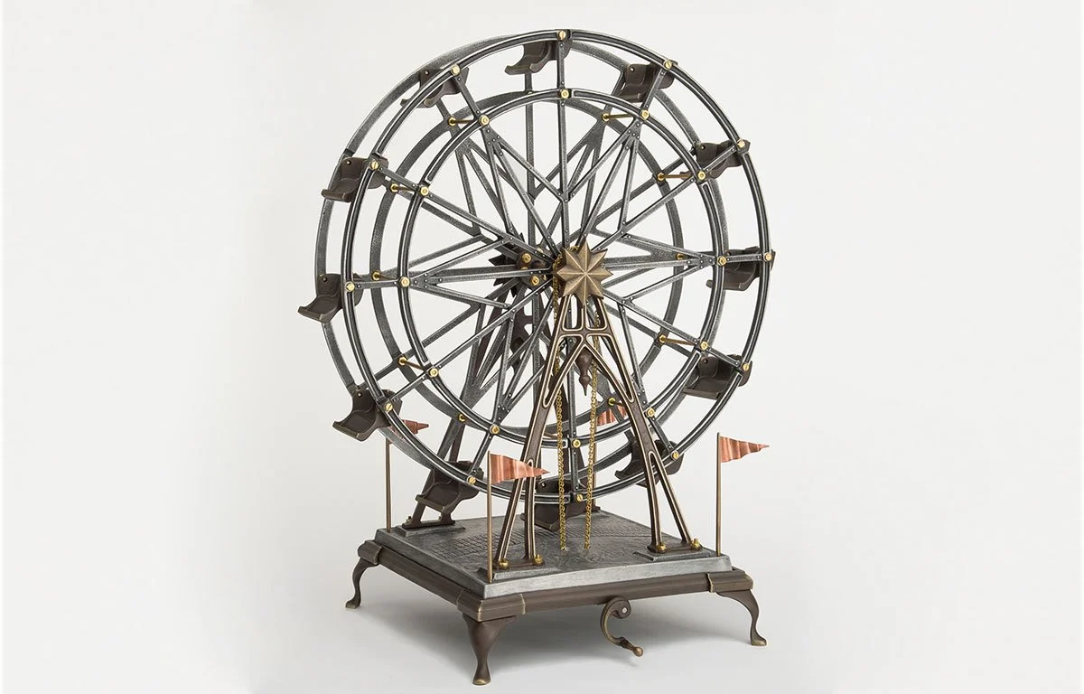 A vintage Ferris wheel clock with intricate metalwork and small flags at its base.