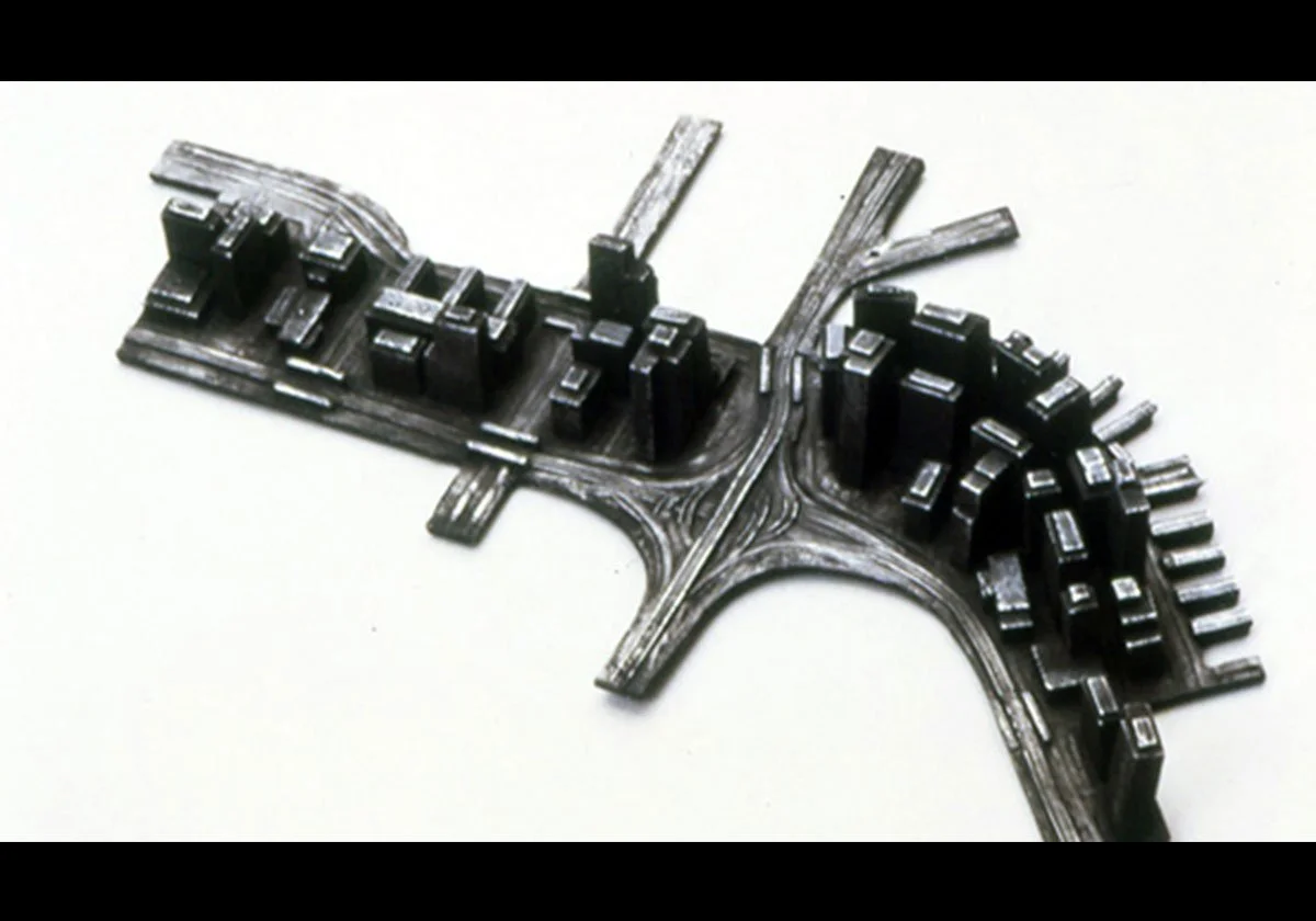 A metallic model of a city layout including buildings, roads, and highways.
