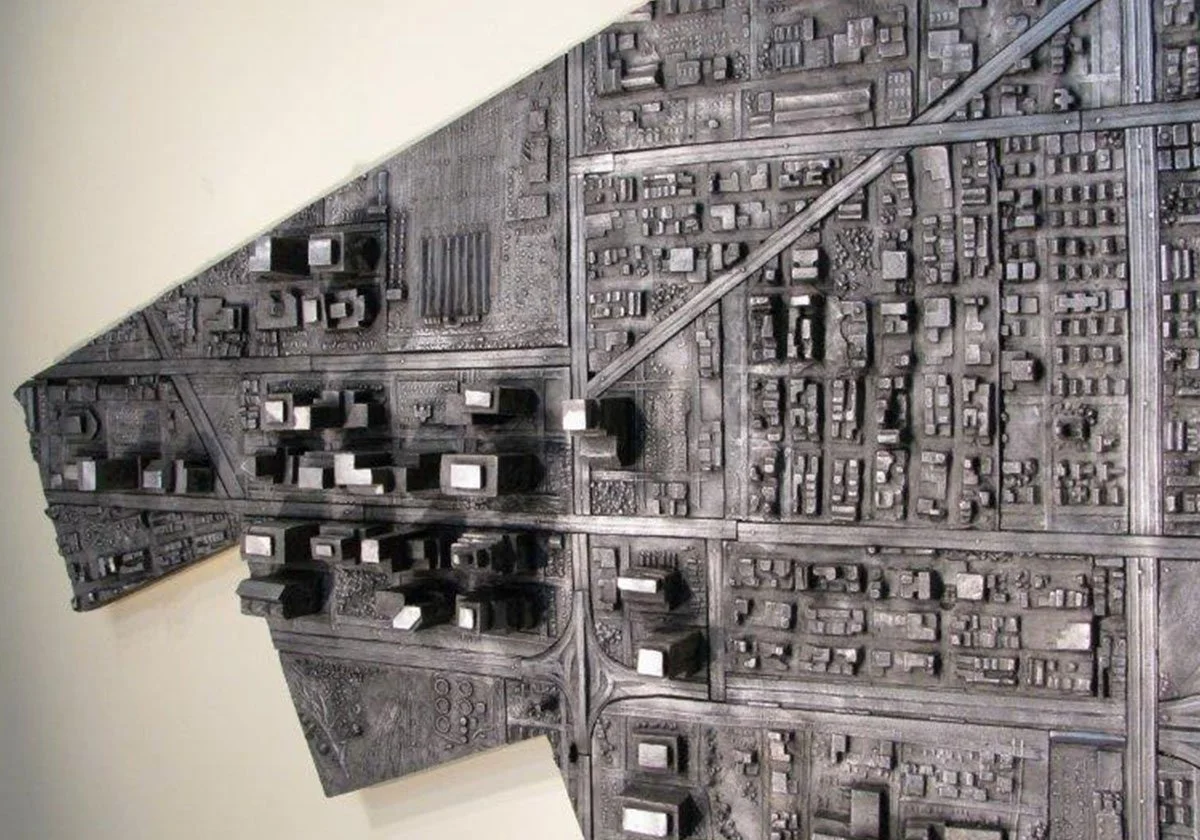 A metallic 3D map of a city layout with detailed streets and buildings, representing an urban area.