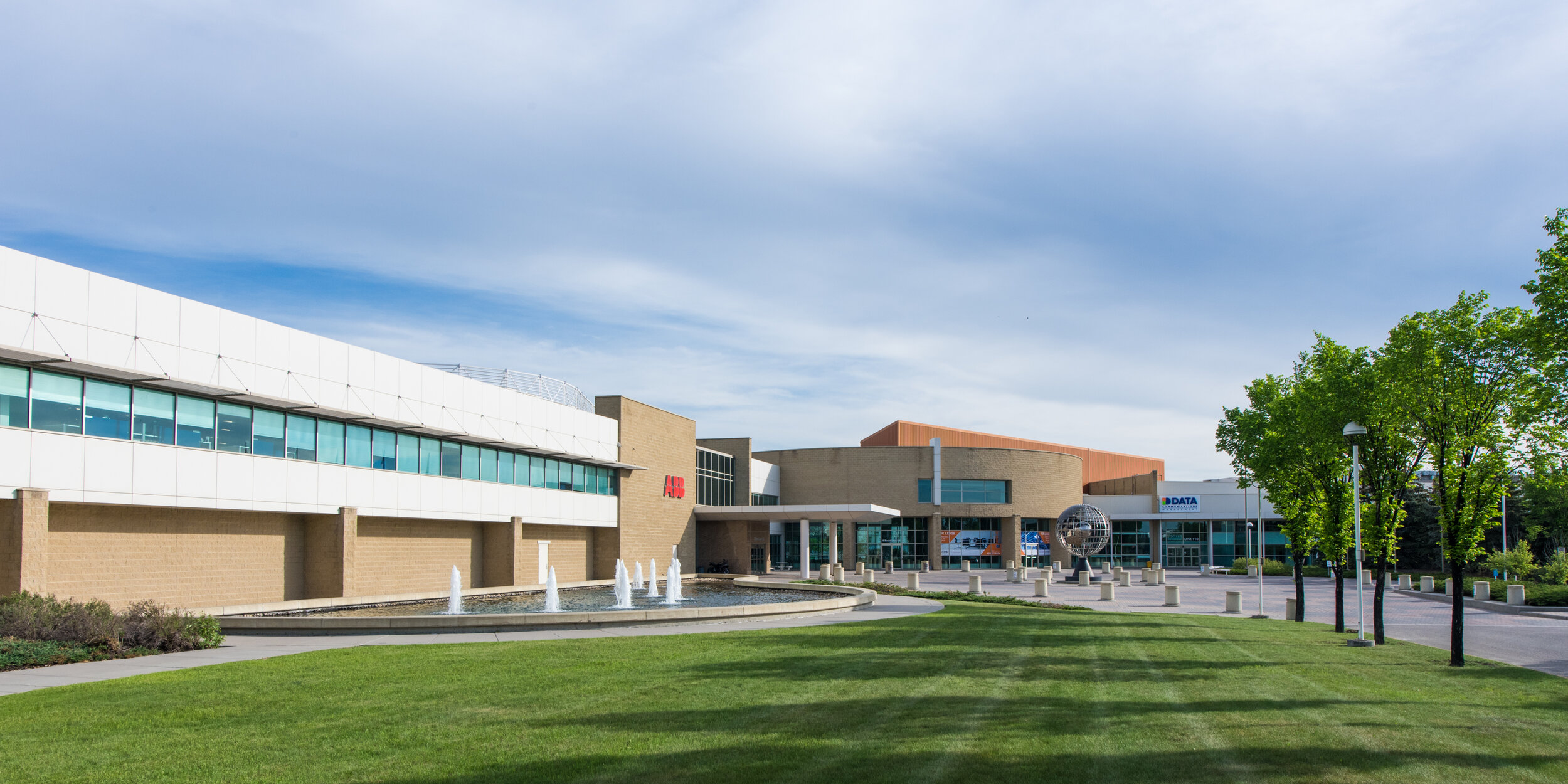 Exterior view of the property and expansive lawn, fountain, and globe sculpture in the foreground (Copy)