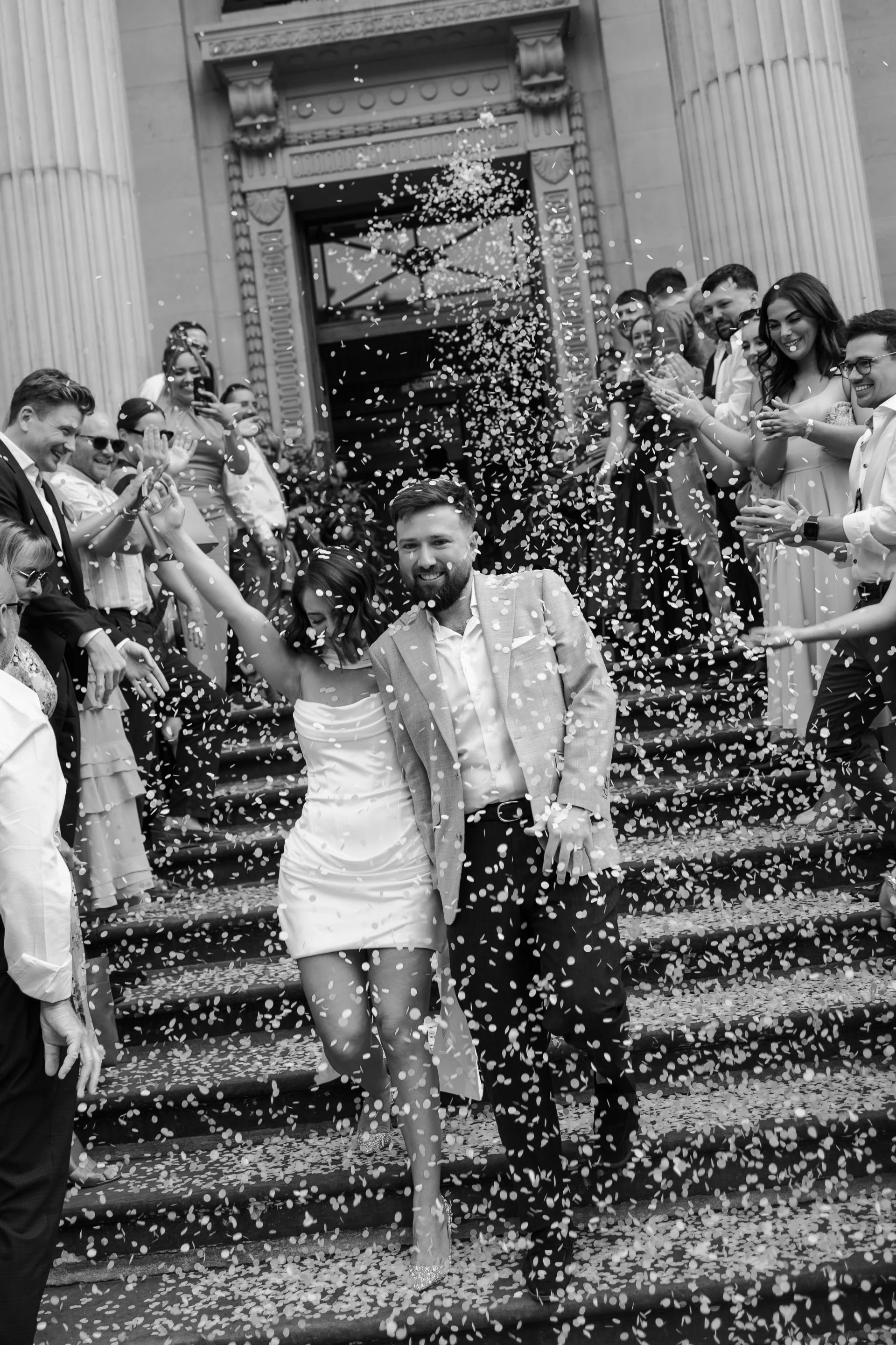 Newlyweds walking through confetti outside Old Marylebone Town Hall in London.