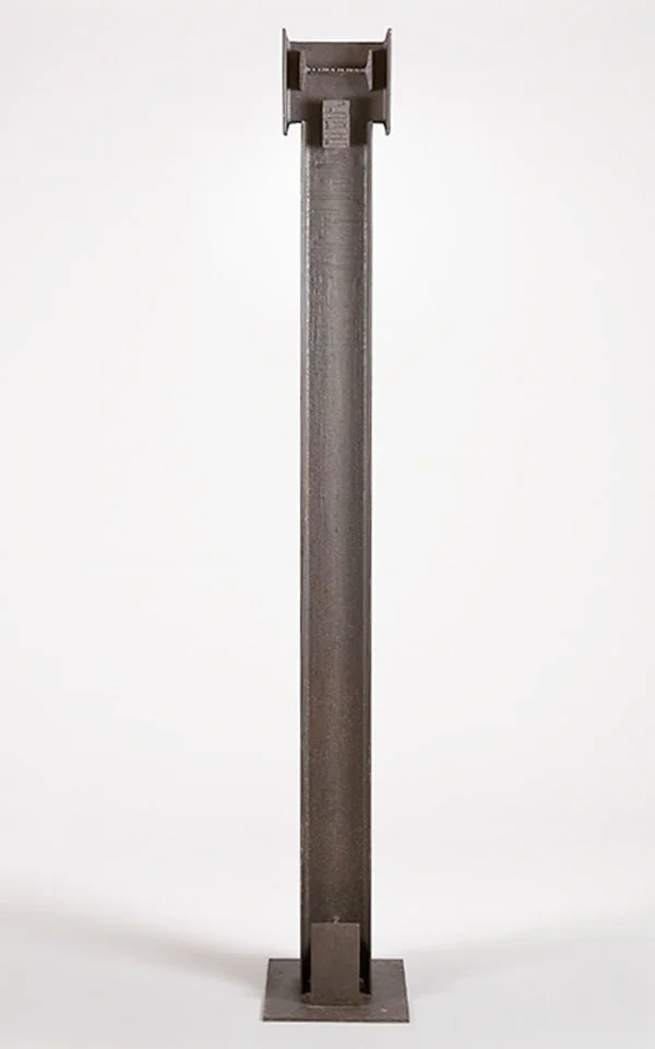 Tall metal sculpture by Angelo Granata resembling a steel beam on a base, minimalist design, industrial style.