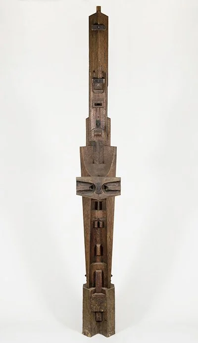 Abstract wooden sculpture by Angelo Granata with geometric shapes on a plain background.