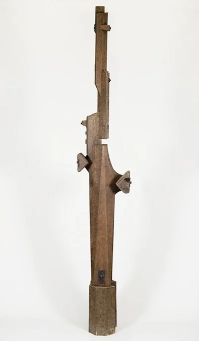 Abstract wooden sculpture by Angelo Granata with geometric shapes and a vertical orientation against a white background.