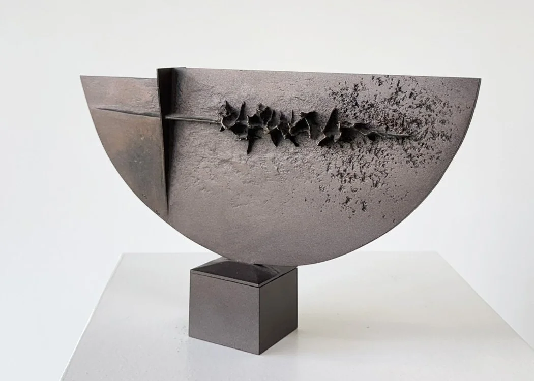 Abstract cast bronze sculpture by Angelo Granata resembling a half-circle with textured surface on a pedestal