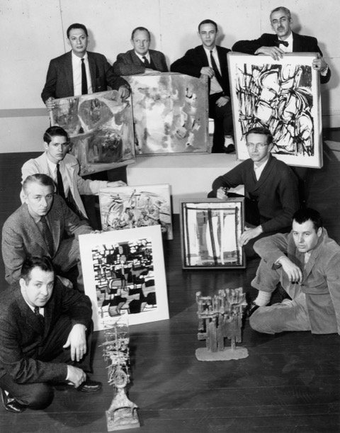 University of Alabama faculty, including Angelo Granata, posing with abstract art pieces in black and white photo