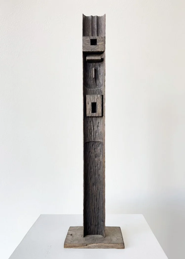 Tall, abstract wooden sculpture by Angelo Granata with rectangular cutouts on a square base.