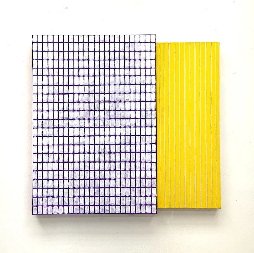 A book with a purple tiled pattern on the cover and a yellow striped spine placed on a white surface.