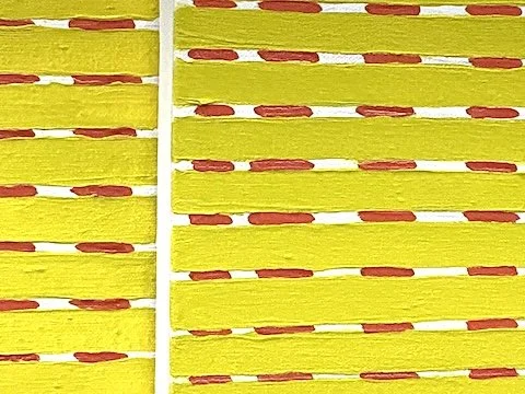 Close-up of a yellow painting with white dividers.