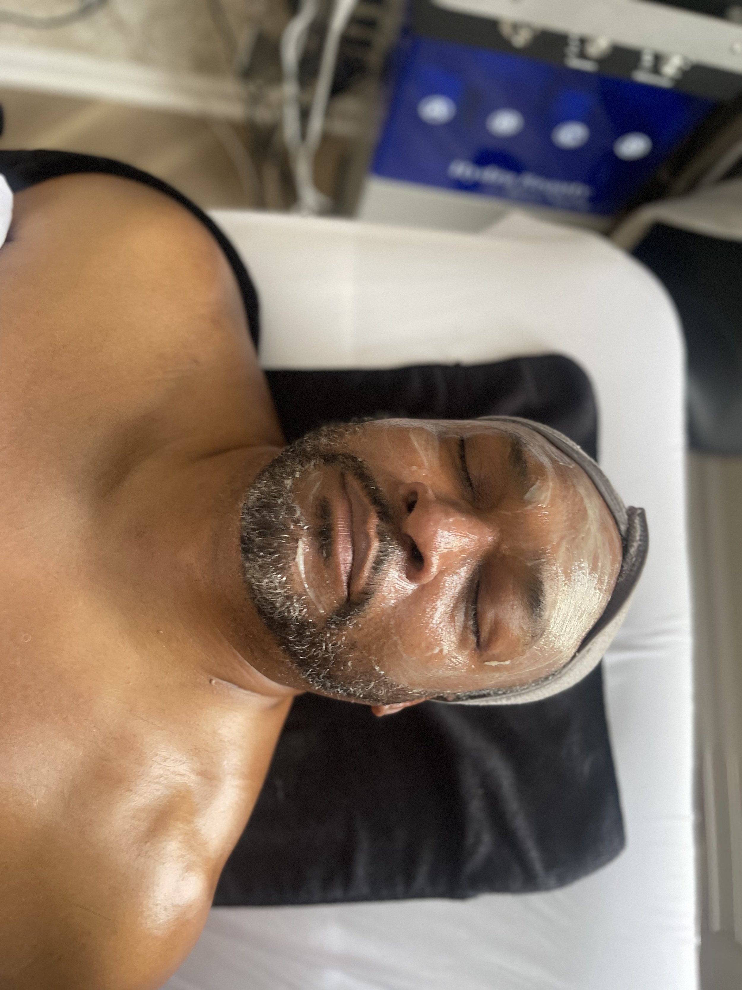 A smiling young man with blond hair, showing white teeth, and looking slightly to the side.