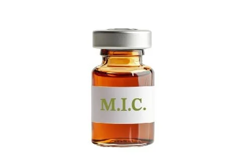 Small glass vial labeled "M.I.C." with amber liquid inside and a gray cap.