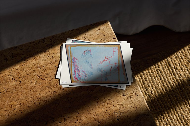 "This Must Be the Place (5)" print displayed in a pile of postcards.