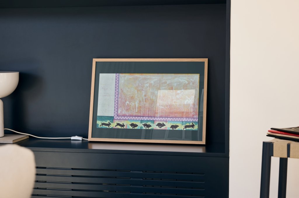 "The Chase" print framed, displayed on an office shelf.