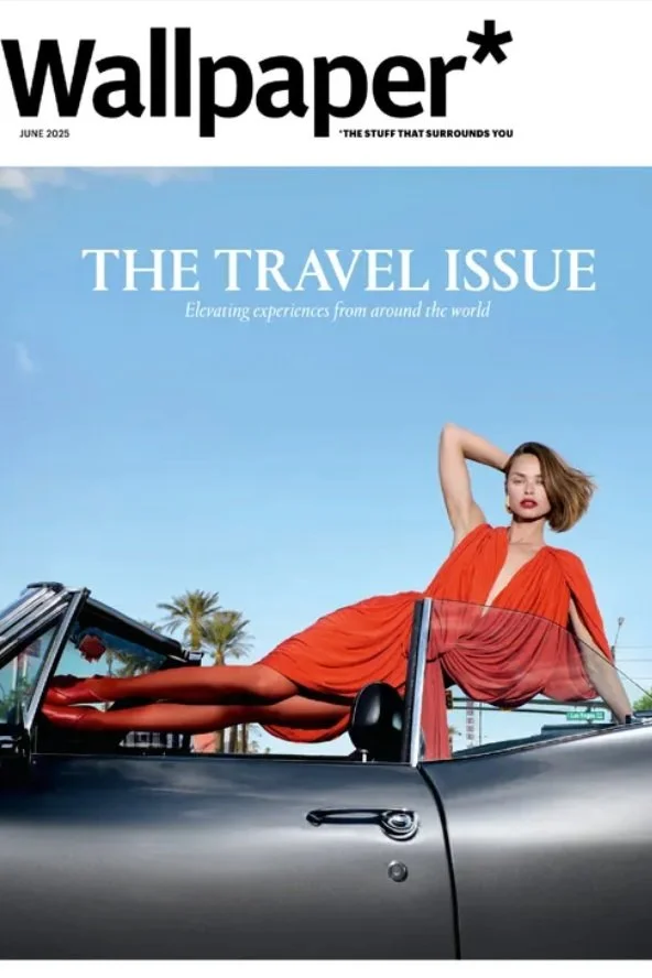 Cover of Wallpaper's June 2025 travel issue featuring a woman in a red dress lying on a car with palm trees and a clear blue sky in the background. The magazine features a story on ceramic artist Lois Samuels.