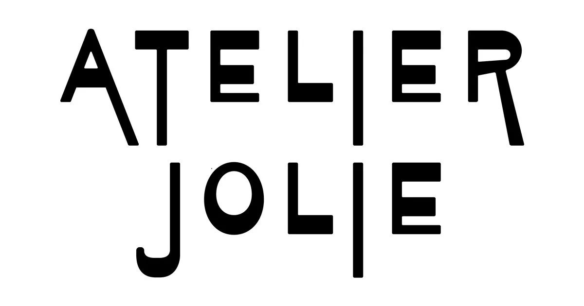 Black text on a white background reads 'ATELIER JOLIE' with a unique design where some letters are split and aligned vertically.