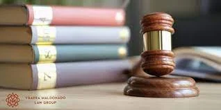 Martillo de juez sobre un libro y varios libros apilados