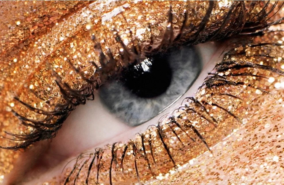 Close-up of high fashion editorial makeup featuring a gold glitter eye. Professional makeup artistry by Robin Schoen.