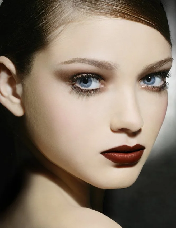 Close-up of a girl with cobalt blue smoky eyes and luminous skin