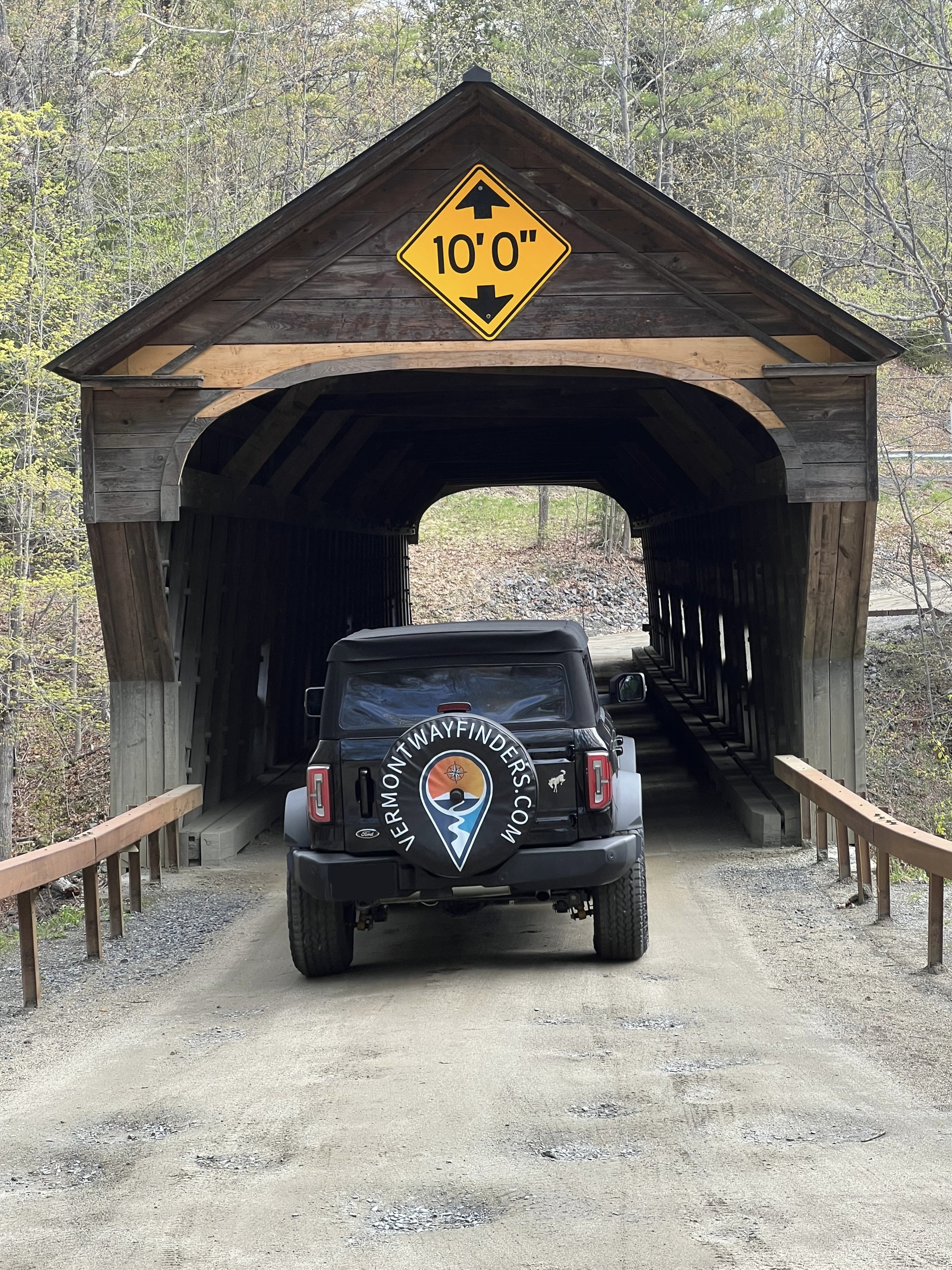 Vermont Wayfinders Bronco driving through a covered bridge.