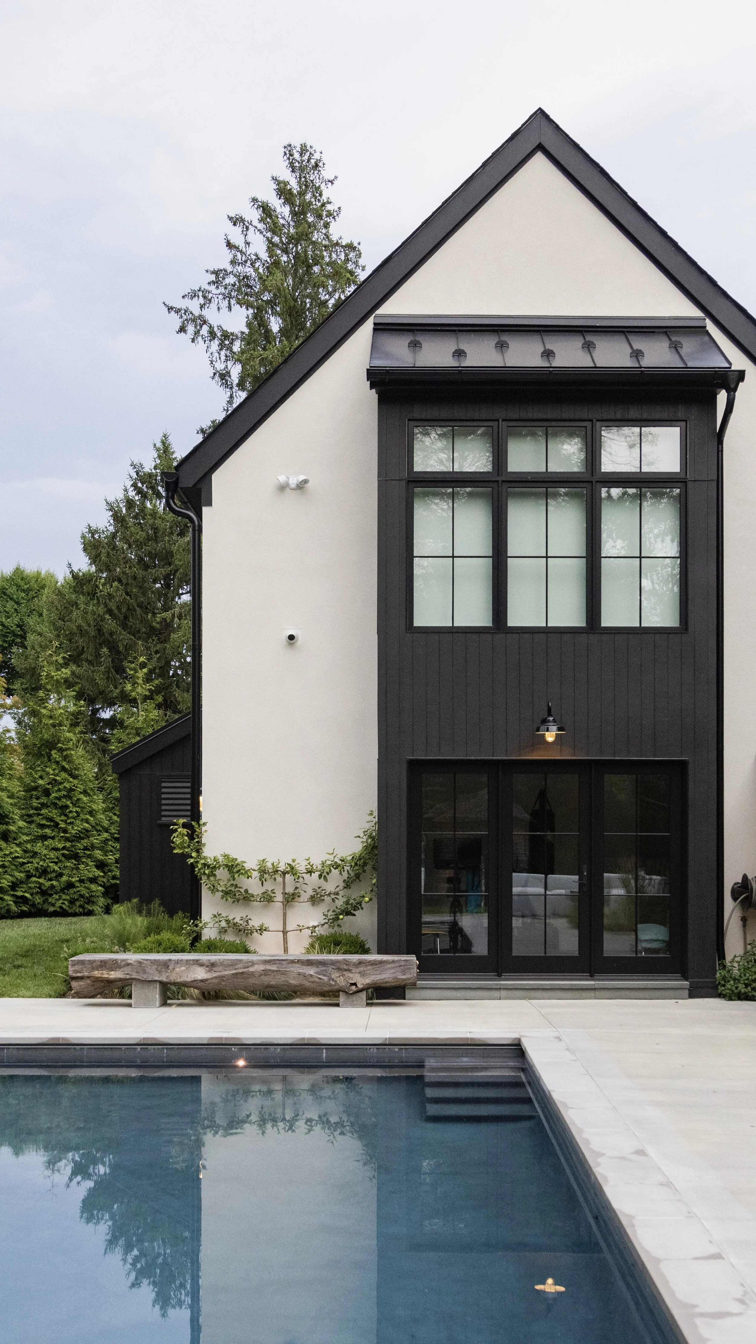 Modern house exterior with a pool and bench