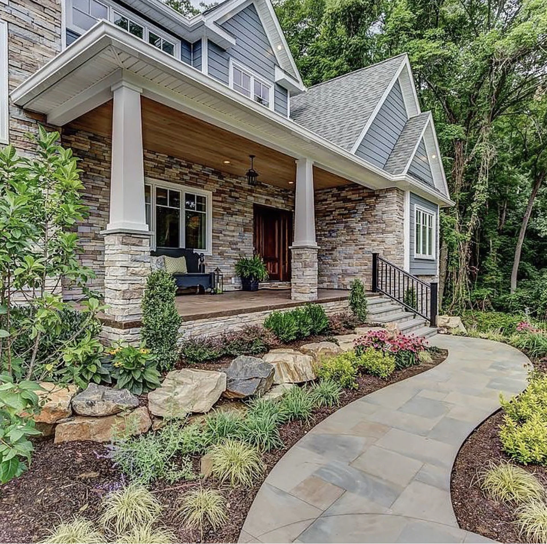 Charming suburban house with stone facade, front porch, and landscaped garden pathway.