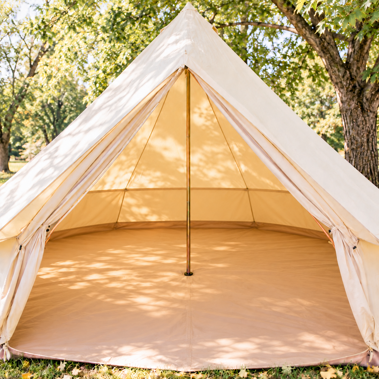 A beige canvas tent set up outdoors among green trees during daytime.