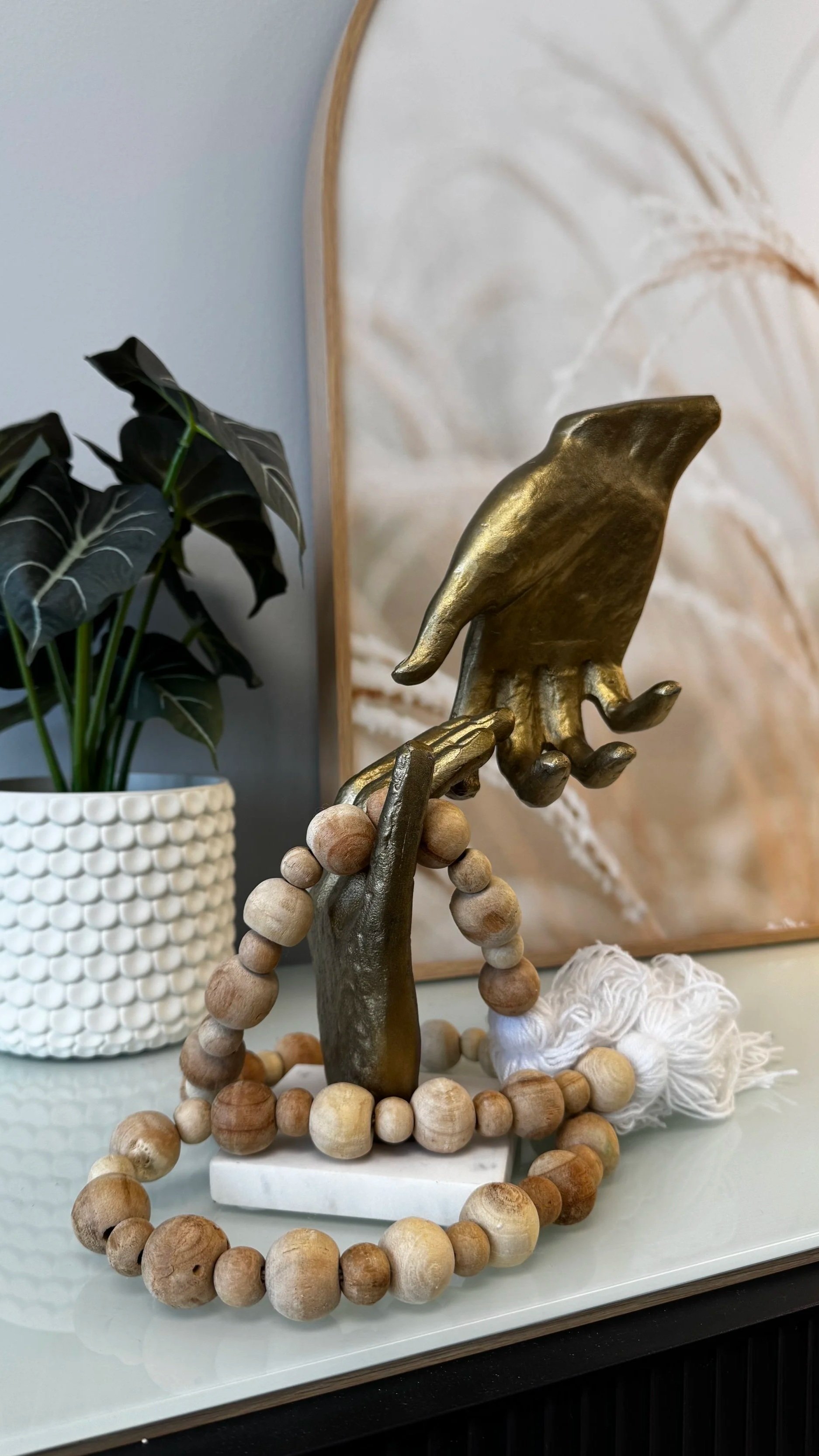 Decorative bronze sculpture of two hands reaching toward one another at A Thread of Clarity in West Edmonton, symbolizing human connection, support, trust, and collaborative healing in therapy.