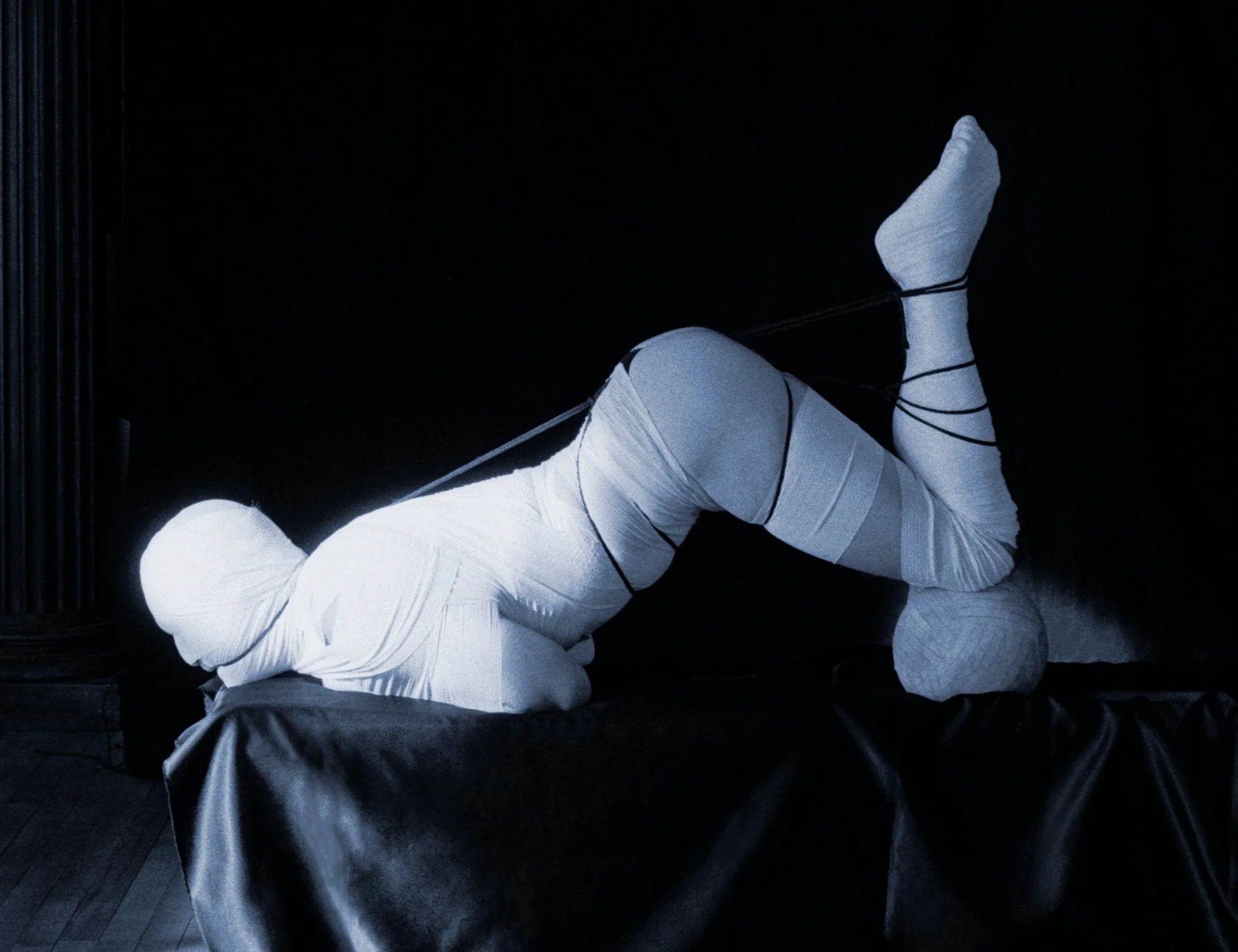 My world is dipped in blue. First comes the bite of the rope—a familiar, smooth claim against their skin. Then, the ghost of the gauze, a mere blanket against their skin. I placed a ball, firm and cool, beneath their knees...and the body had no choic
