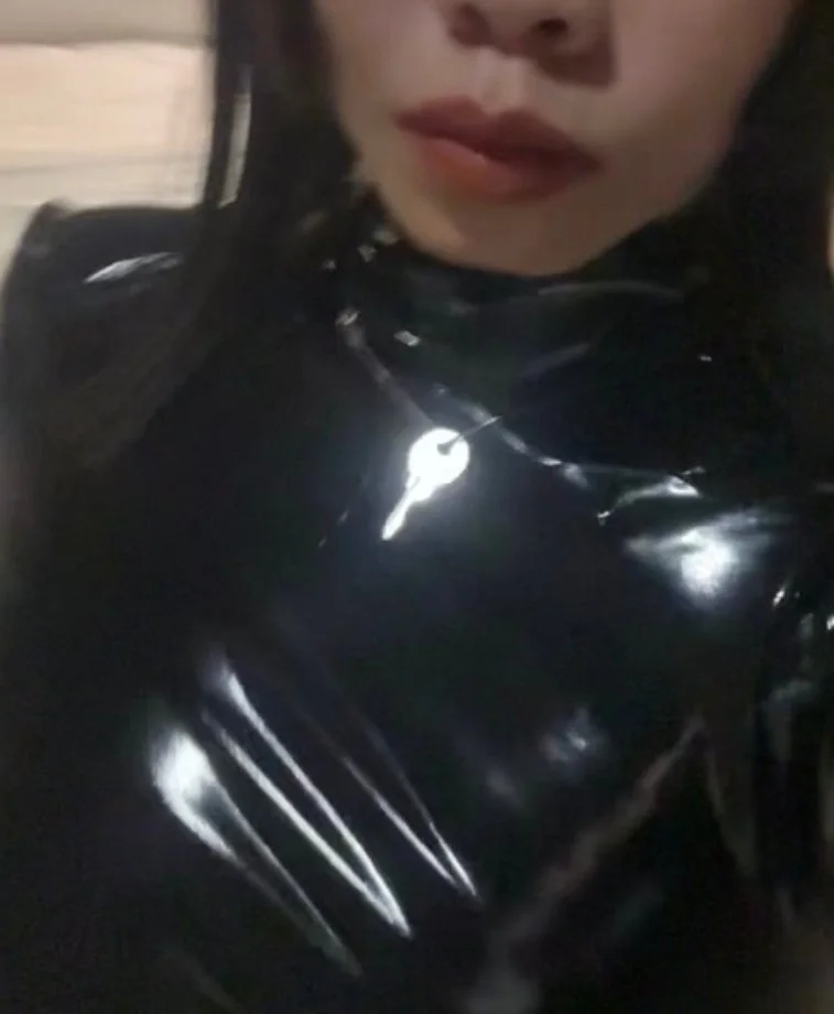 Person wearing a shiny black latex outfit.