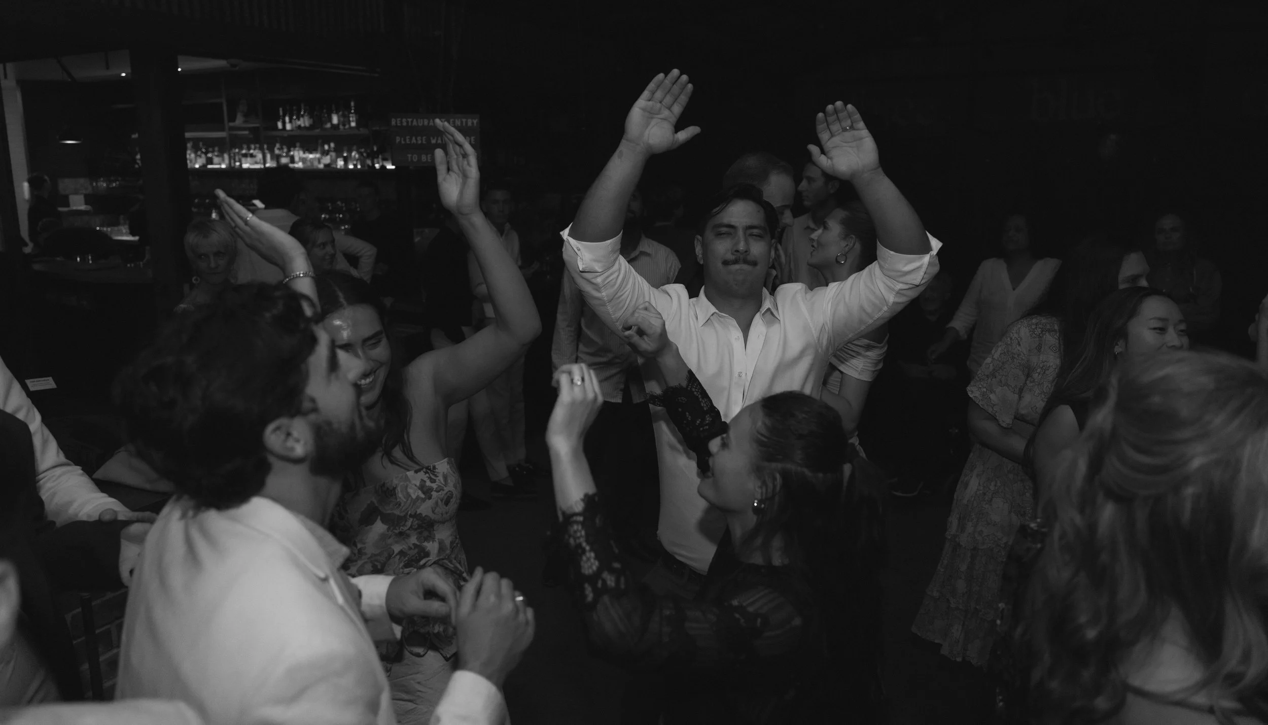 People dancing and having fun at a party or celebration in a dimly lit venue.