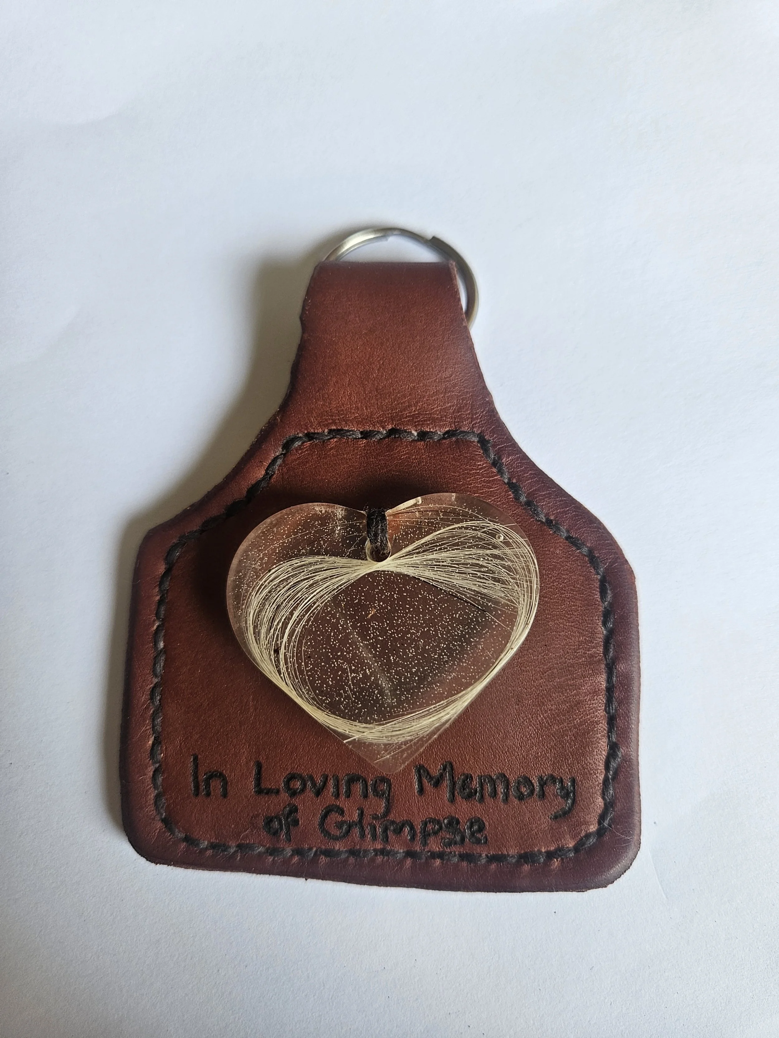 Leather memorial keychain with a gold heart-shaped pendant and the inscription 'In Loving Memory of Glimpse'.