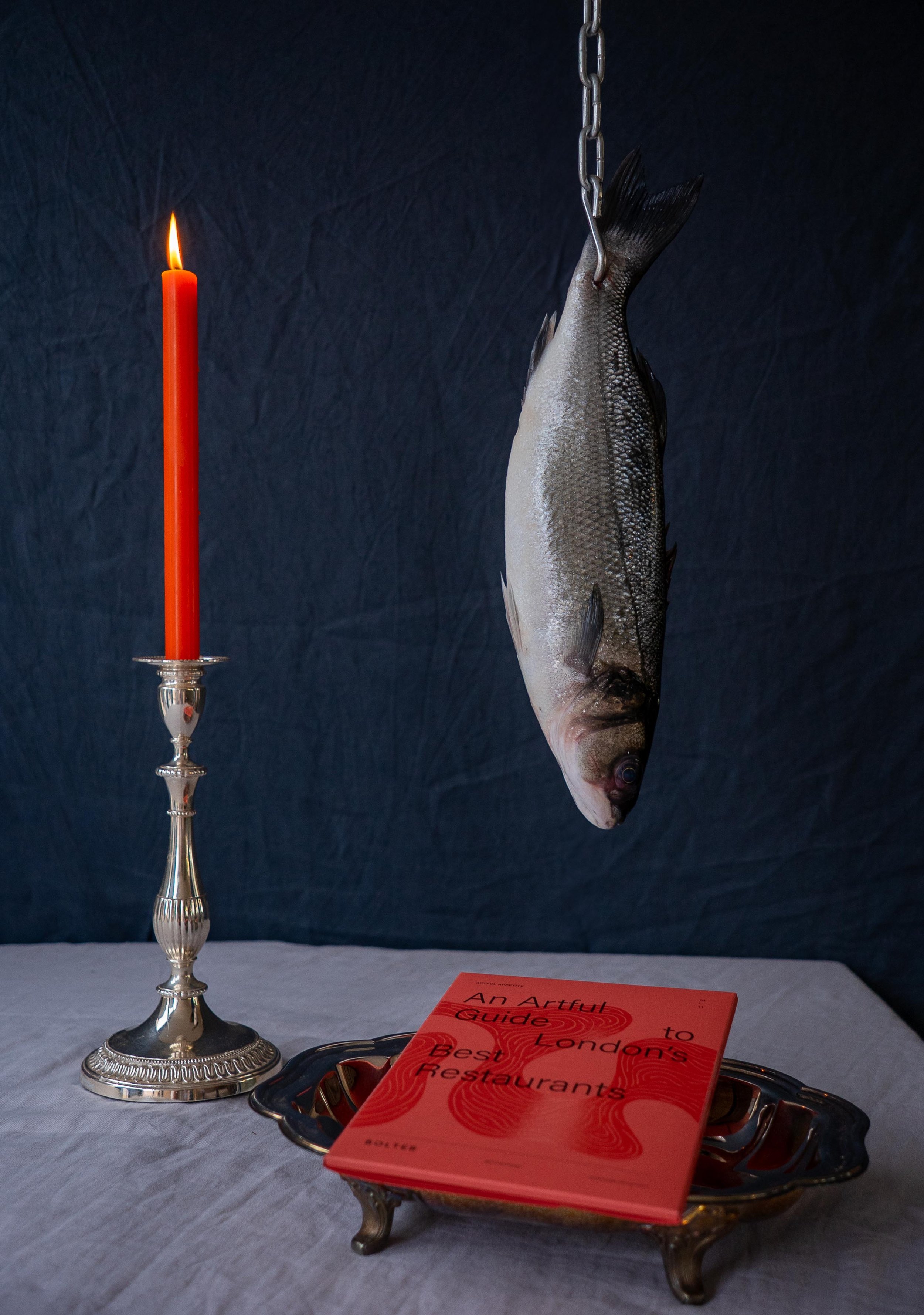 Bolter Design Artful Appetite restaurant cards with a red candle and fish hanging from above