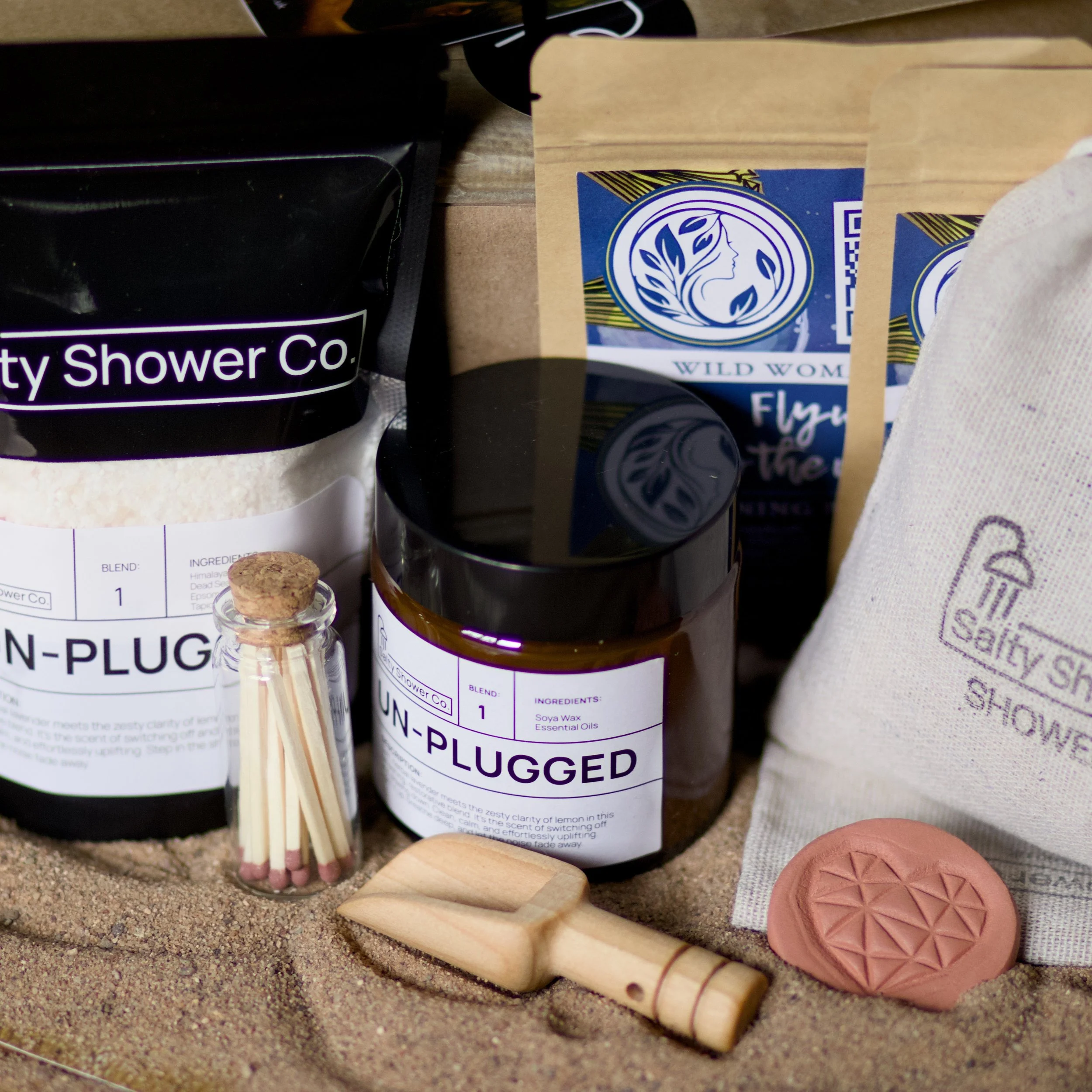 Salty Notes Premium Gift Bag Upgrade featuring a rustic burlap gift bag, linen shower bags, shower salts, soy candle, wooden salt scoop, glass jar of matches, scented disc, and relaxing herbal tea
