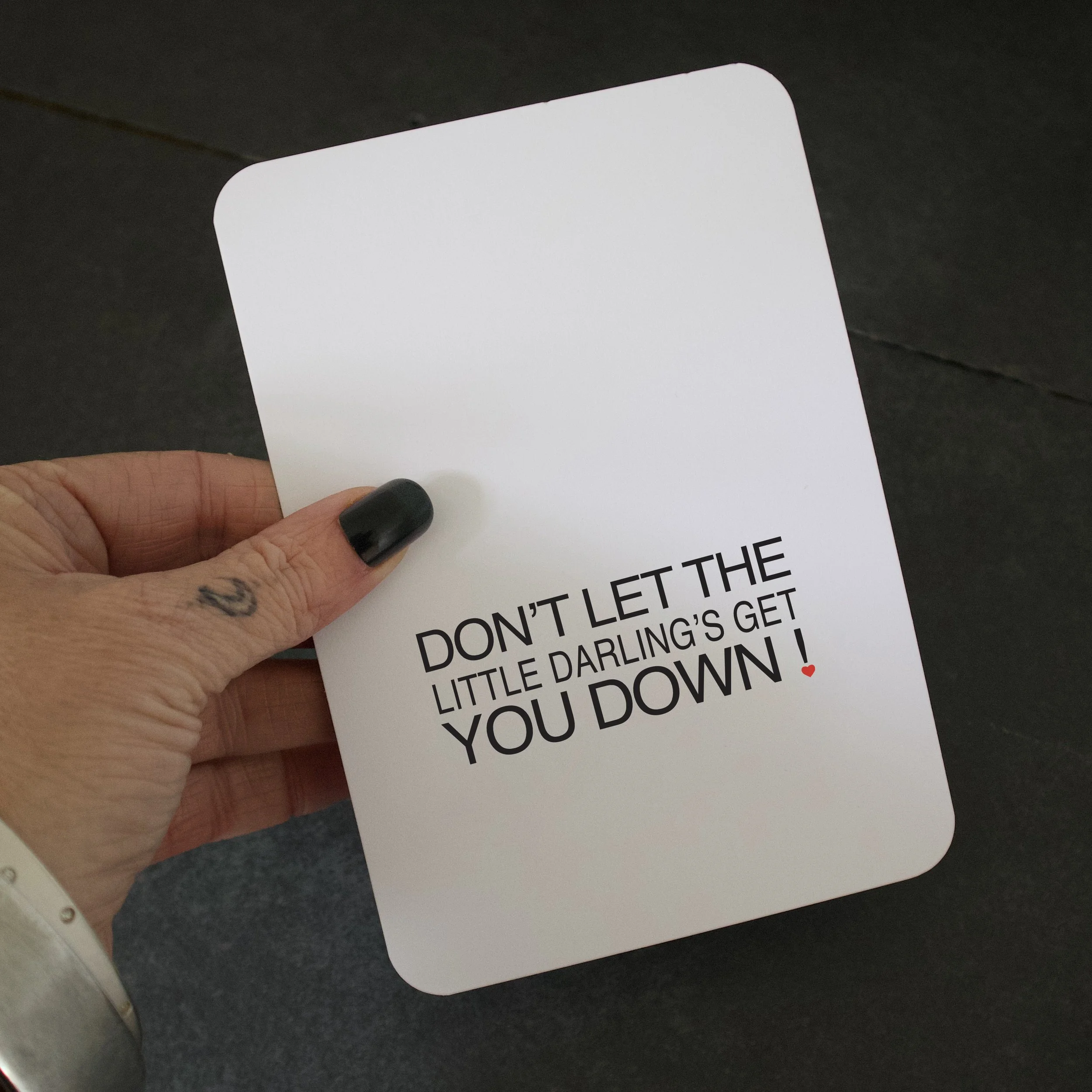 Don't let the little darlings get you down! Postcard for the teacher or TA in your child's life in a hand.