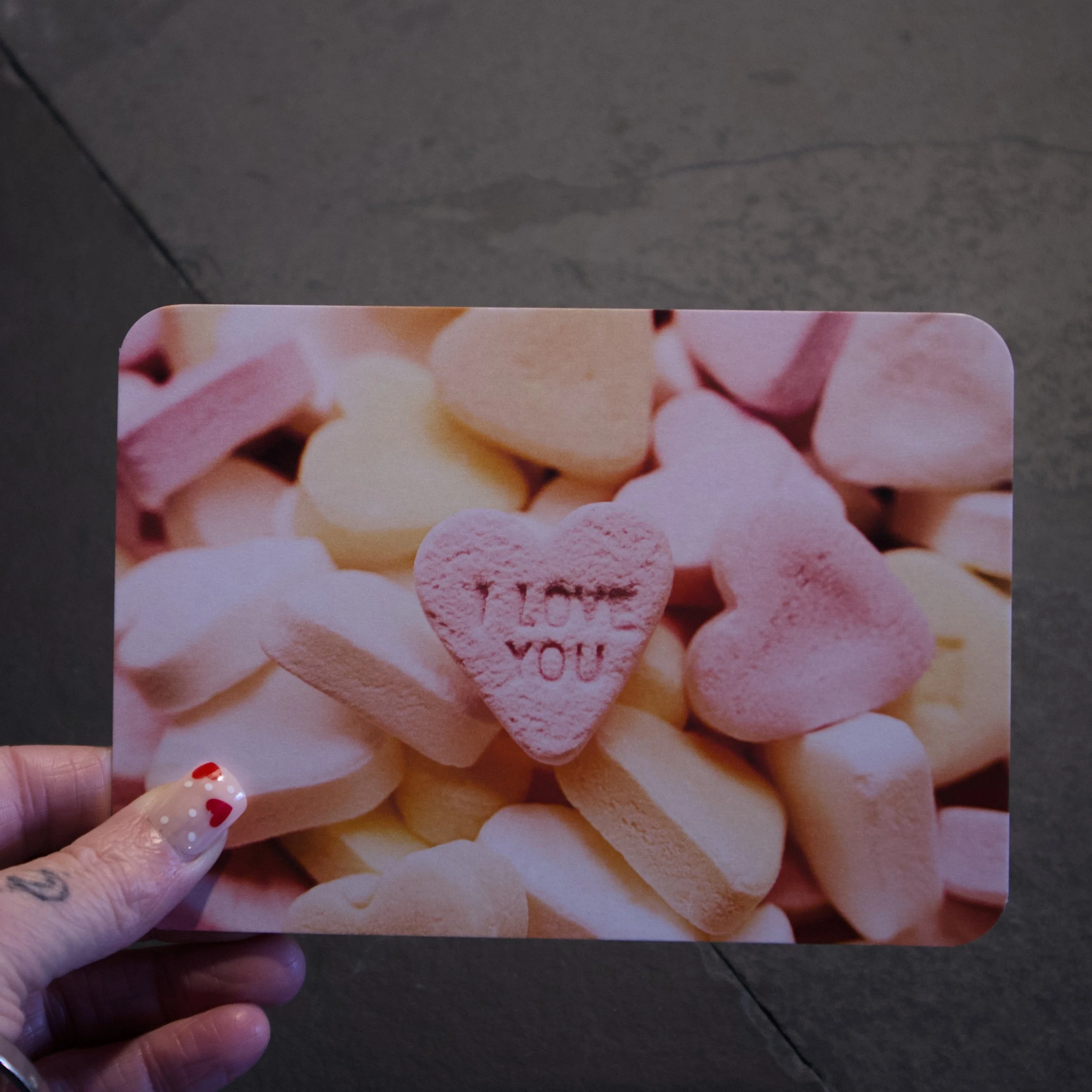 Candy Heart Interesting photograph of a pile of pink, orange, and yellow candy hearts with I LOVE YOU embossed into one - Salty Note