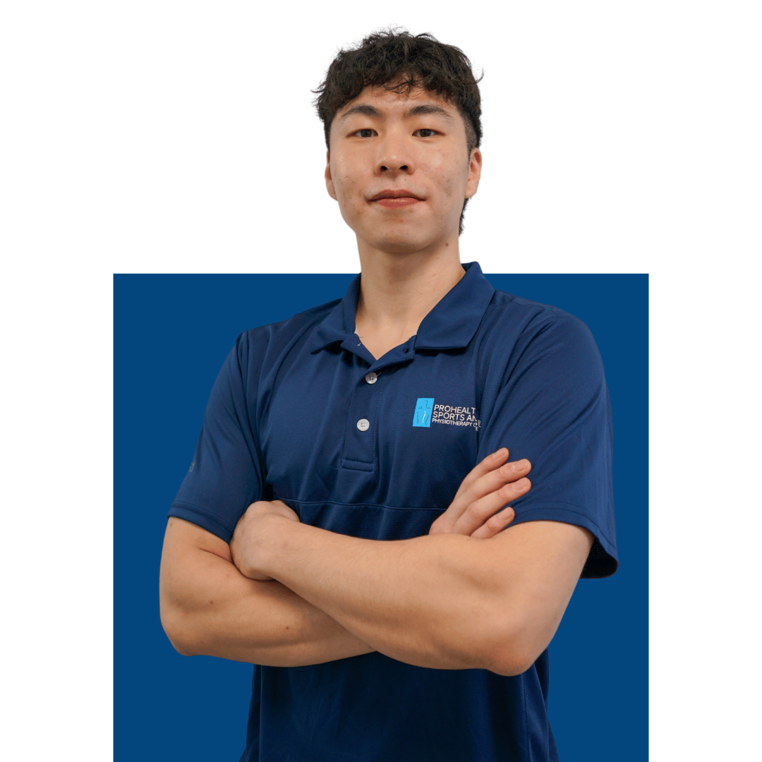 A man with short black hair and light skin, wearing a navy blue polo shirt with a logo that reads "ProHealth Sports and Physical Therapy." He stands with arms crossed against a blue background, looking directly at the camera with a neutral expression.