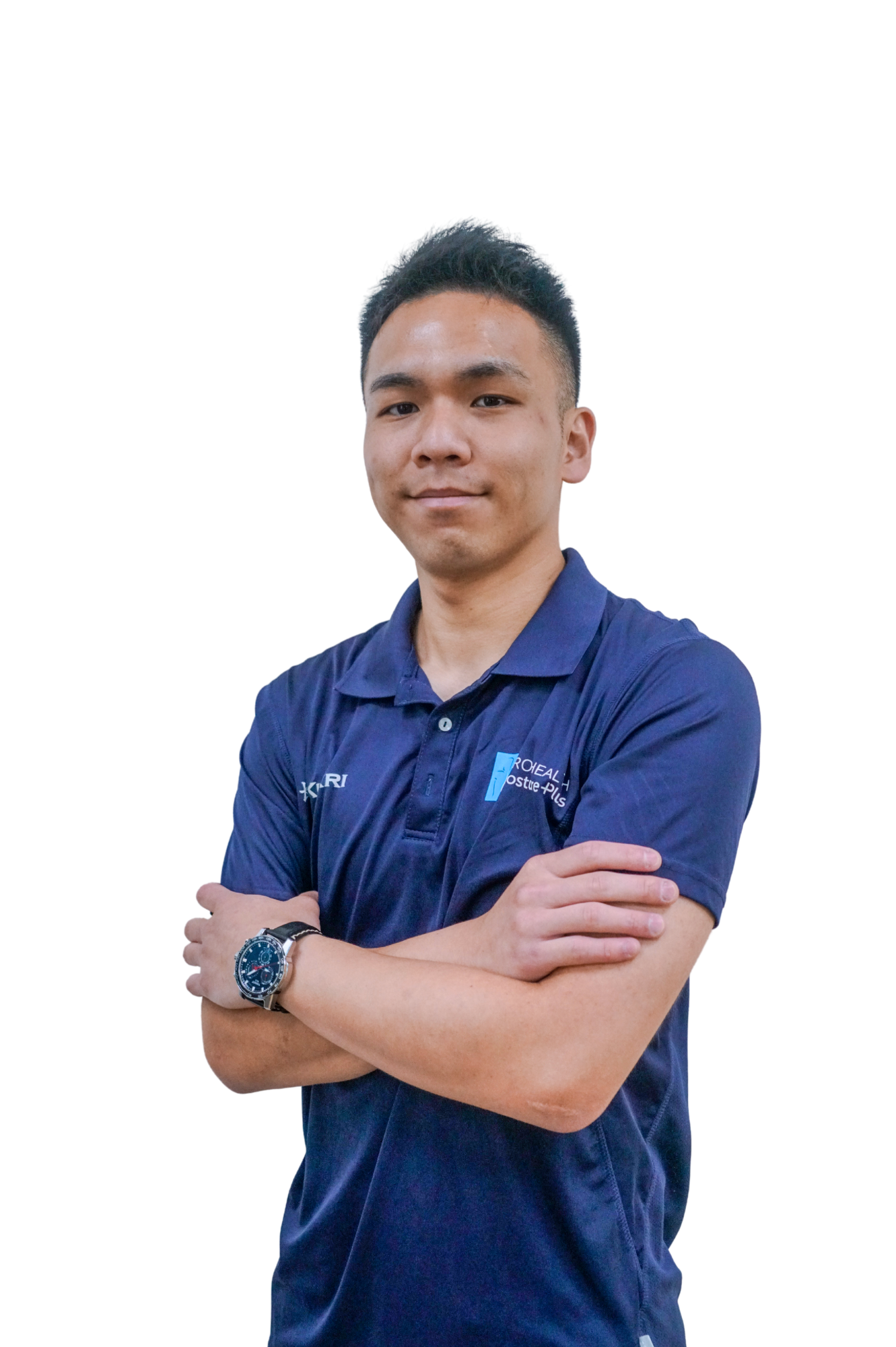 A young man with short black hair and light skin tone posing with arms crossed, wearing a navy blue polo shirt and a wristwatch, standing against a plain white background.