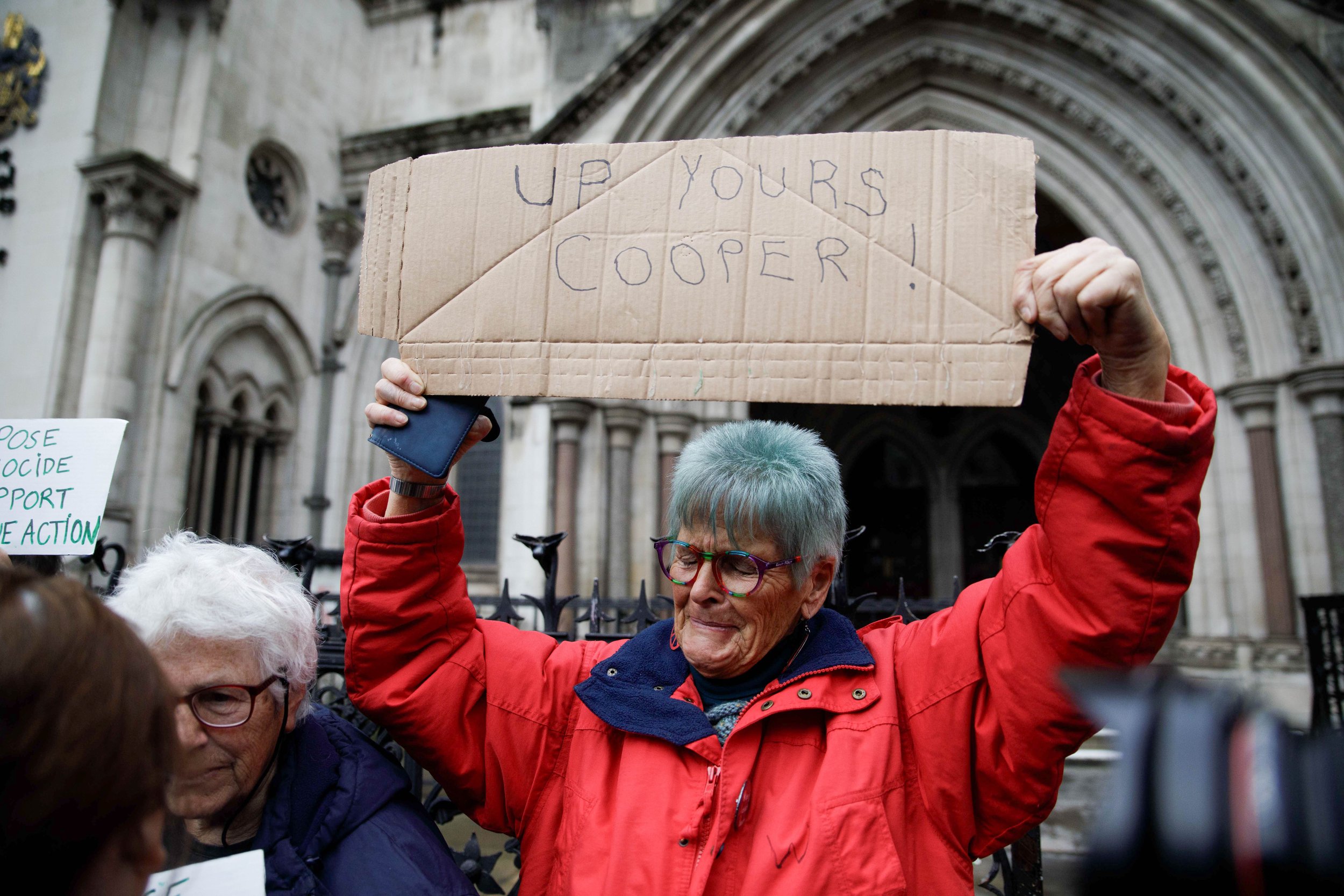 A woman holds sign aloft in front of Royal Courts of Justice as the UK Government’s Ban on Palestine Action as a terrorist organisation has been ruled unlawful in the High Court. Royal Courts of Justice, London, 13th FEBRUARY 2026.
(Credit:Charlie Mc