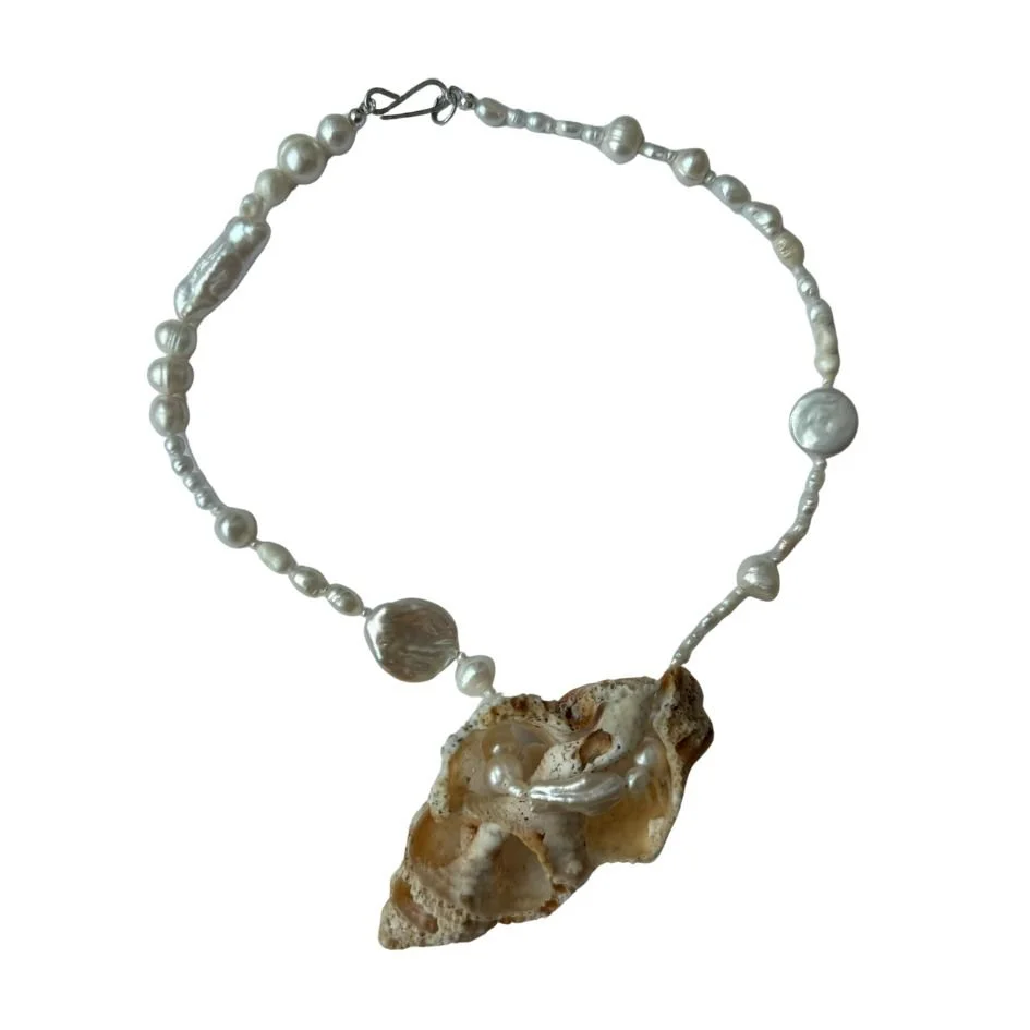 Necklace made of pearls with a large shell pendant.