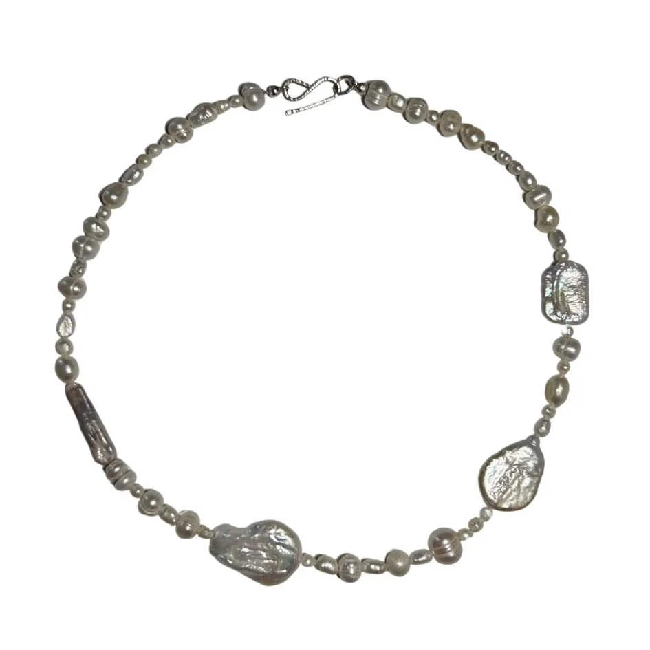 Pearl necklace with silver irregularly shaped pendant pieces and a clasp.
