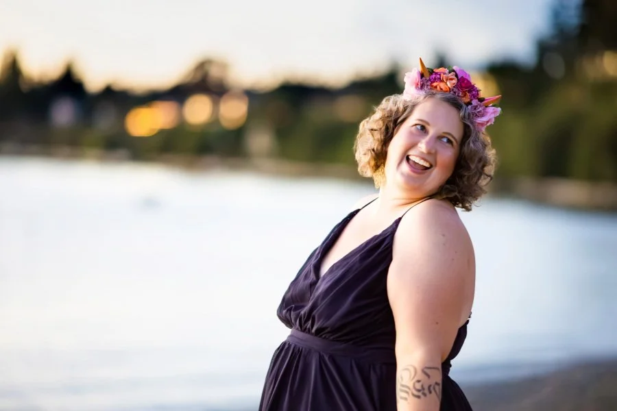 Annie Mesaros, spiritual counselor and founder of Wild Maven Wellness, smiling by the water.
