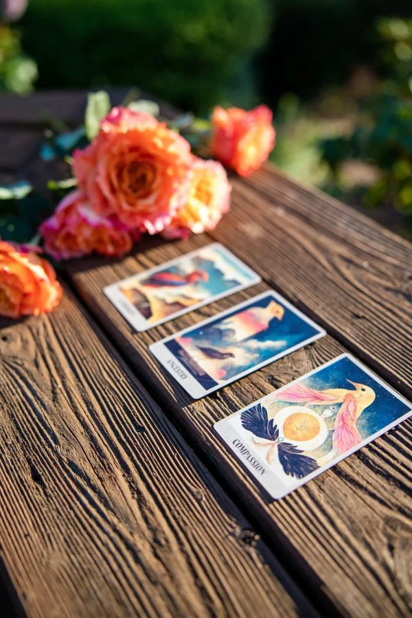 Orange and pink roses on wooden bench with Oracle cards