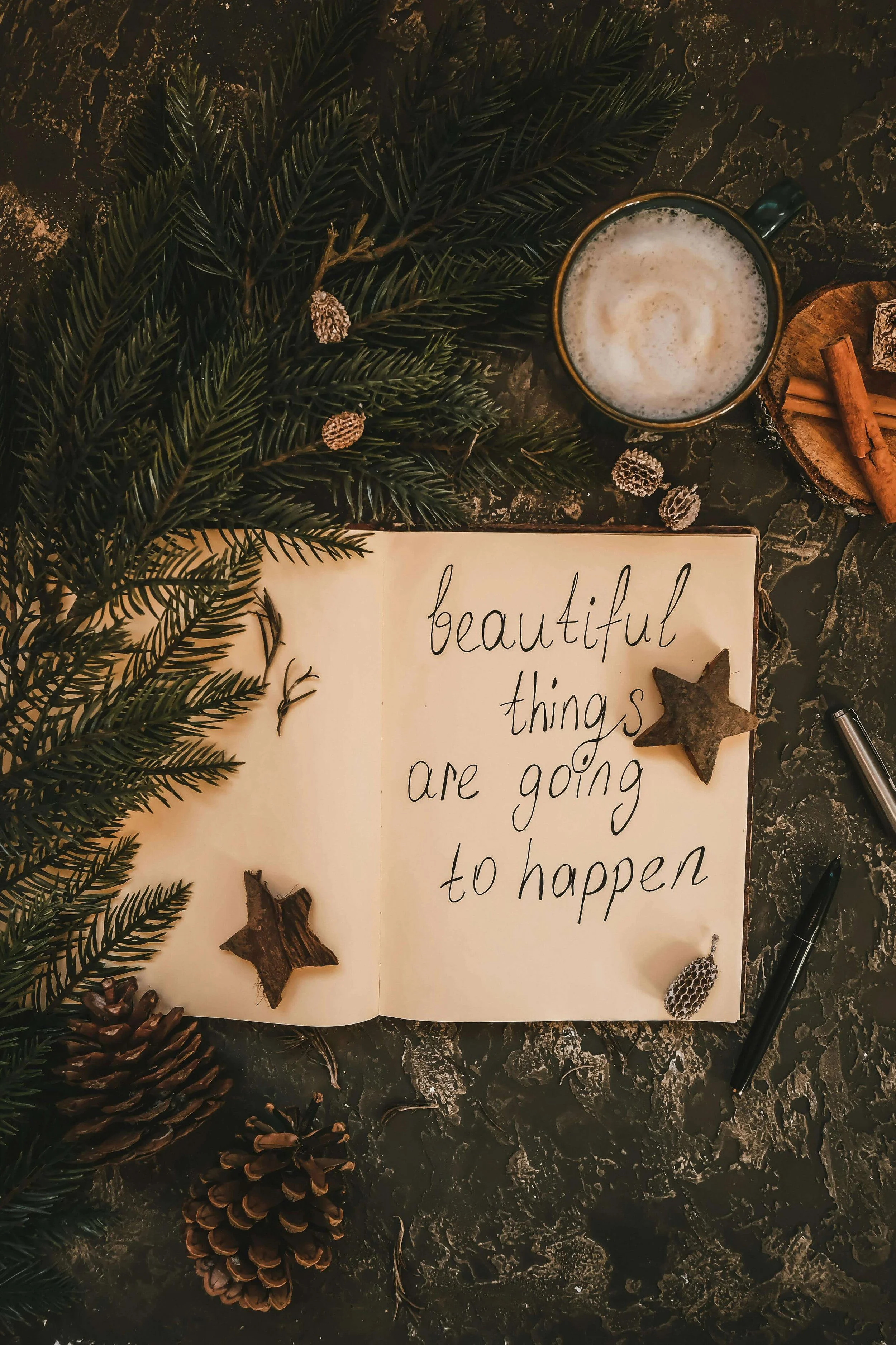 Evergreens and journal with the phrase, beautiful things are going to happen