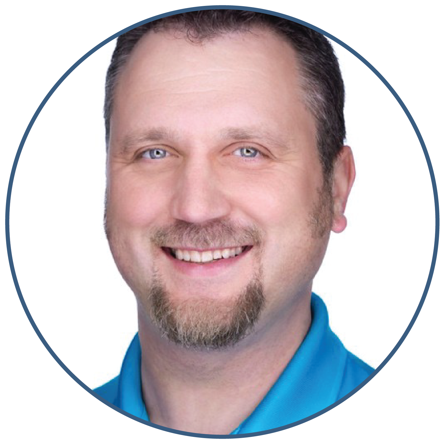Smiling man with short hair and goatee in blue shirt, close-up portrait on white background.
