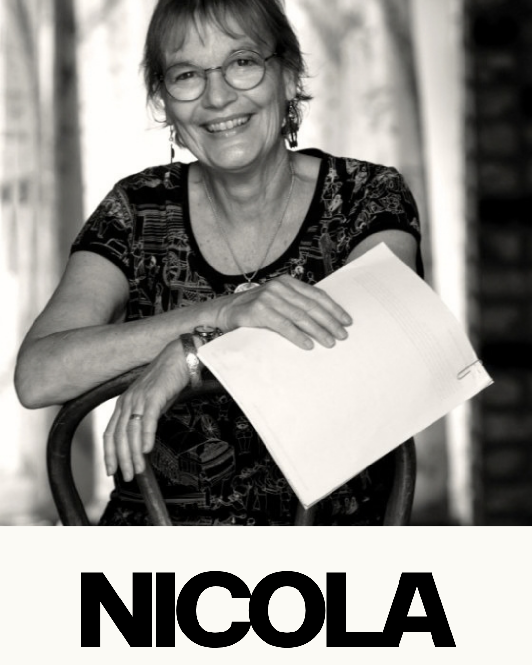 Black and white photo of a smiling woman with glasses, holding a notebook, sitting on a chair, with the name 'NICOLE' in bold letters at the bottom.